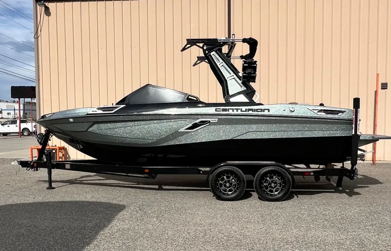 Slide: The Image of 2024 Centurion Ri230 boat on trailer, parked outdoors. - 2