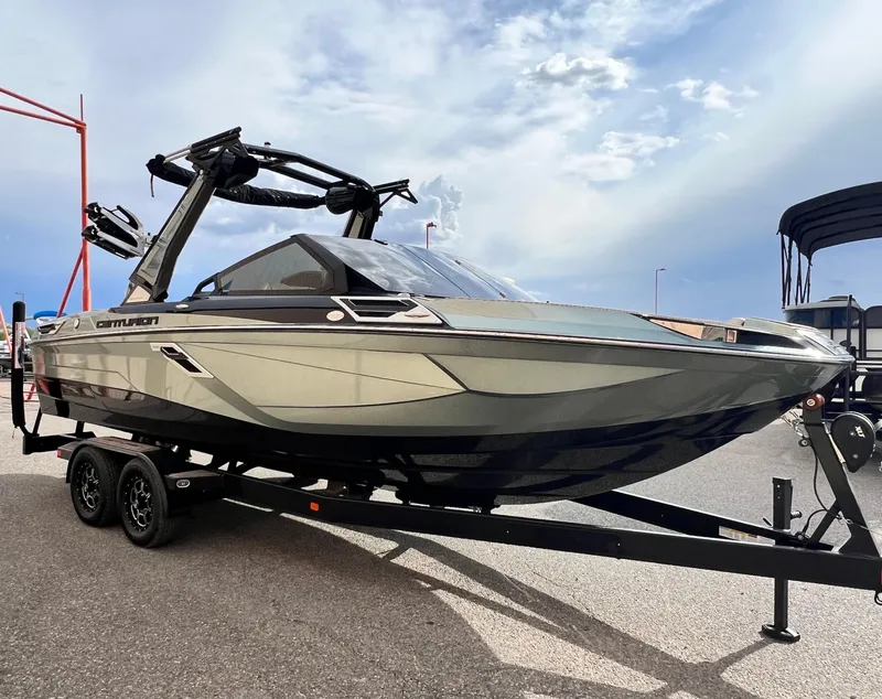 Slide: The Image of 2024 Centurion Ri230 boat on trailer, sleek design, parked outdoors. - 3