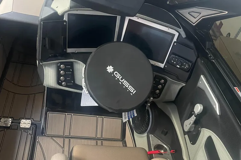 Slide: The Image of 2024 Centurion Ri230 boat dashboard with dual screens and Gussi steering wheel. - 6