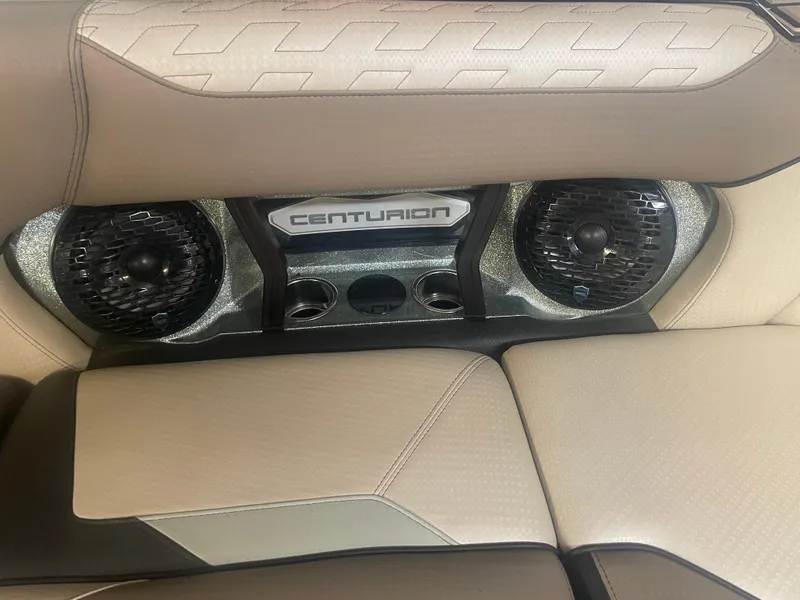 Slide: The Image of 2024 Centurion Ri230 boat interior with premium speakers and beige upholstery. - 7