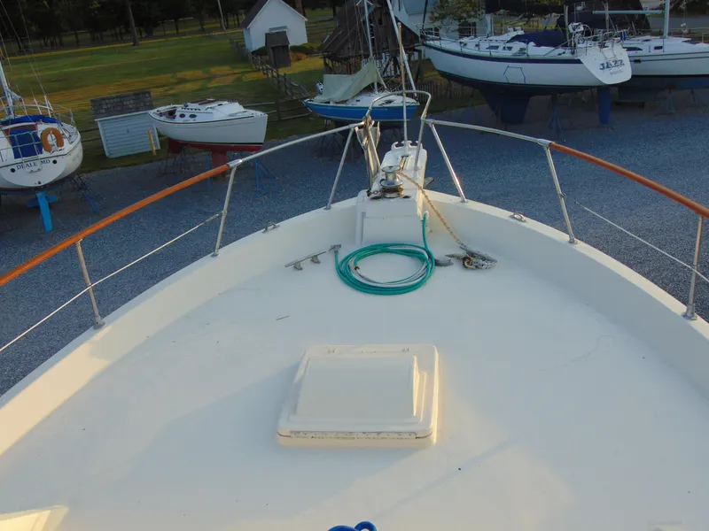 Slide: The Image of 1972 Hatteras Yachtfish with blue paddleboard on deck, surrounded by parked boats. - 30