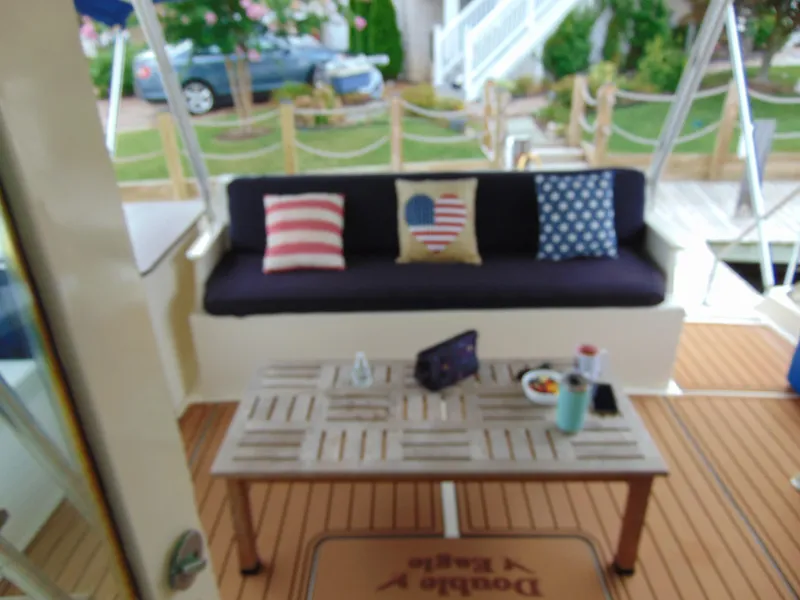 Slide: The Image of 1972 Hatteras Yachtfish docked in a marina with sailboats and cars nearby. - 34