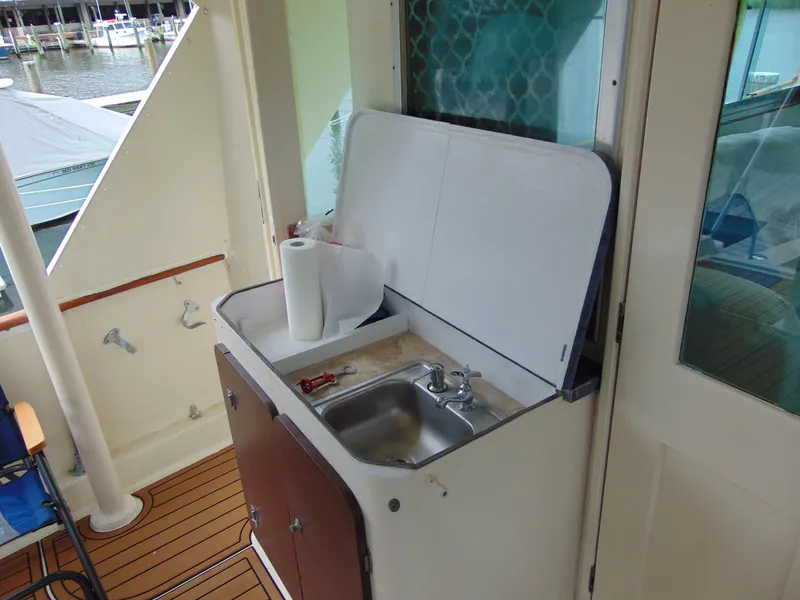 Slide: The Image of 1972 Hatteras Yachtfish deck with patriotic-themed cushions and a wooden table. - 37