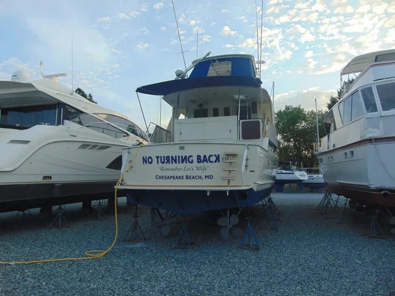 Slide: The Image of 1972 Hatteras Yachtfish docked at marina, featuring blue canopy and wooden deck. - 4