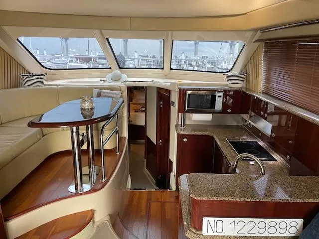 Slide: The Image of Luxurious interior of 2007 Sea Ray 52 Sedan Bridge yacht with modern kitchen and seating area. - 25