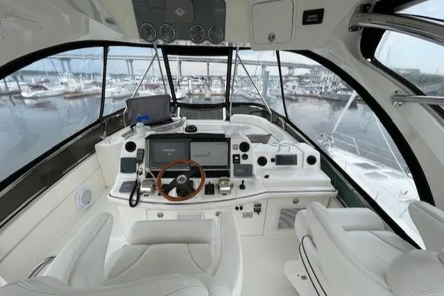 Slide: The Image of 2007 Sea Ray 52 Sedan Bridge helm with marina view, featuring modern navigation equipment. - 5