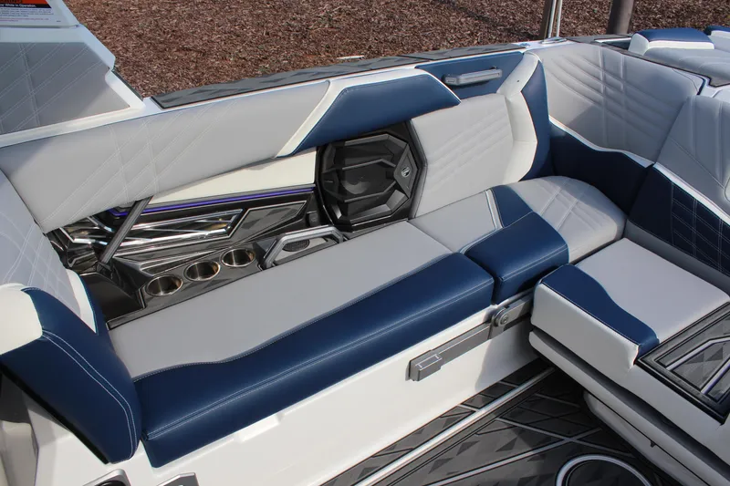 Slide: The Image of 2025 Tigé Ultré 25ZX boat interior with blue and white seating and cup holders. - 10