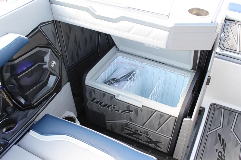 Slide: The Image of 2025 Tigé Ultré 25ZX boat interior with open cooler and speaker system. - 18