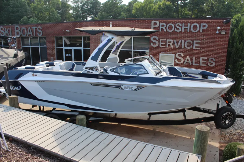 Slide: The Image of 2025 Tigé Ultré 25ZX boat displayed at a dealership, showcasing sleek design and modern features. - 6
