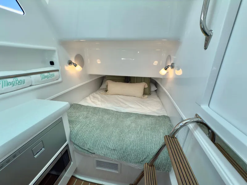 Slide: The Image of 2026 Mag Bay 38 CC boat interior with teak flooring and white cabinetry. - 21