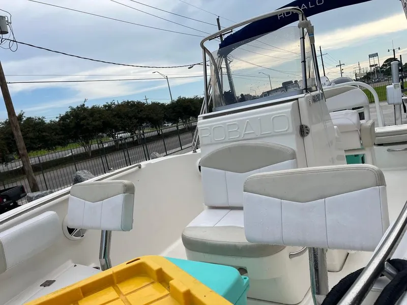 Slide: The Image of 2016 Robalo R200 Center Console boat with seating and storage, parked outdoors. - 14