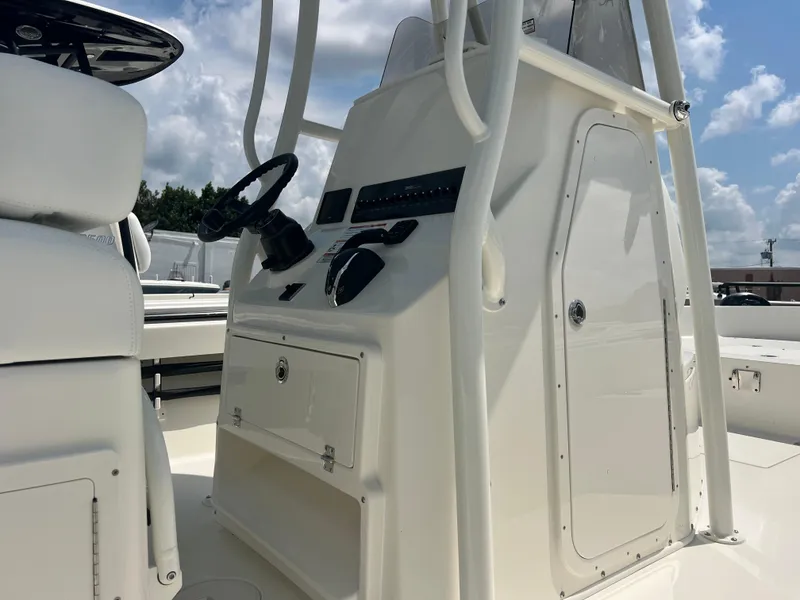 Slide: The Image of 2025 Pathfinder 2600 TRS boat console with steering wheel and controls under a blue sky. - 3