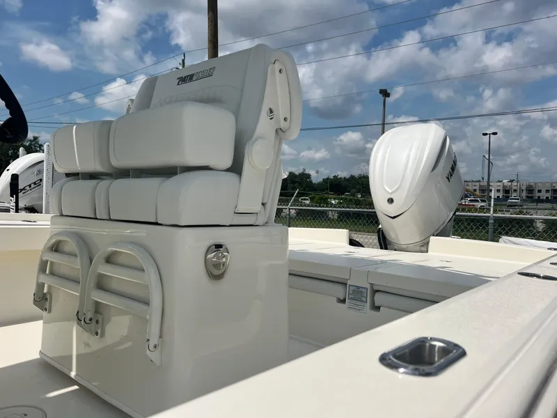 Slide: The Image of 2025 Pathfinder 2600 TRS boat interior with seating and motor, under a partly cloudy sky. - 9