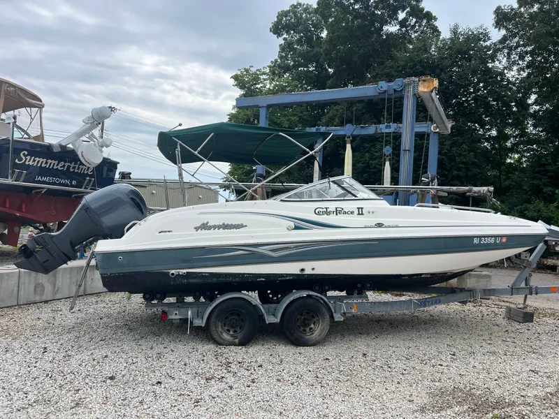 The Image of 2006 Hurricane SunDeck 237 DC OB boat on trailer, parked outdoors. - 0