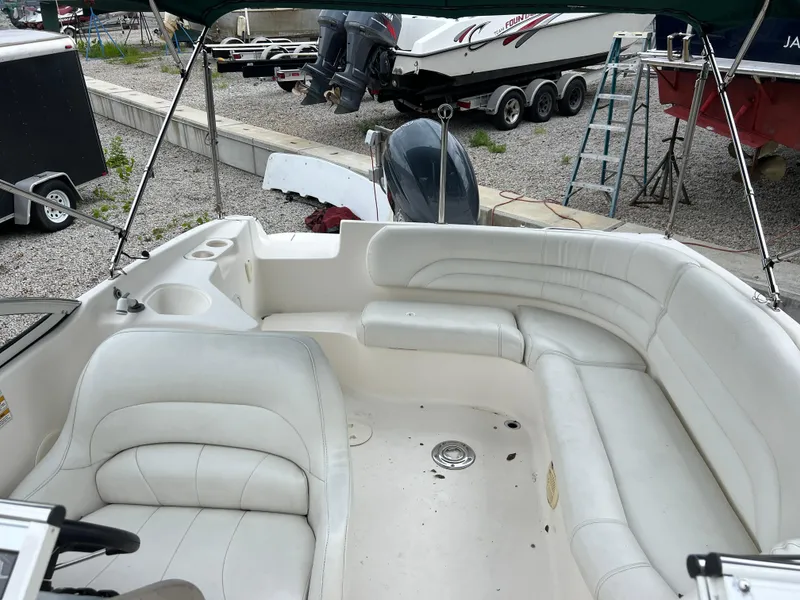 Slide: The Image of 2006 Hurricane SunDeck 237 DC OB boat interior with white seating and cup holders. - 11