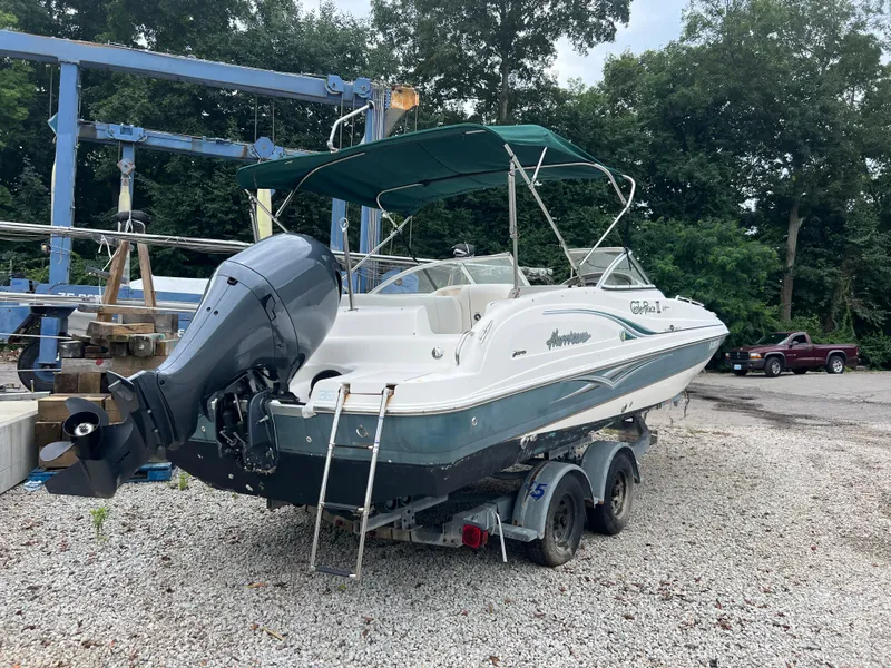 Slide: The Image of 2006 Hurricane SunDeck 237 DC OB boat on trailer, parked outdoors. - 4