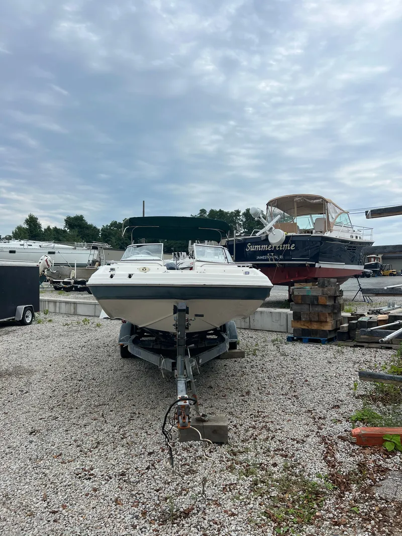 Slide: The Image of 2006 Hurricane SunDeck 237 DC OB boat on trailer in a gravel lot. - 6