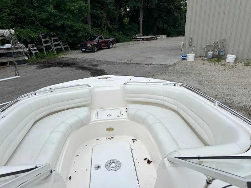 Slide: The Image of 2006 Hurricane SunDeck 237 DC OB boat with spacious white seating, parked outdoors. - 8
