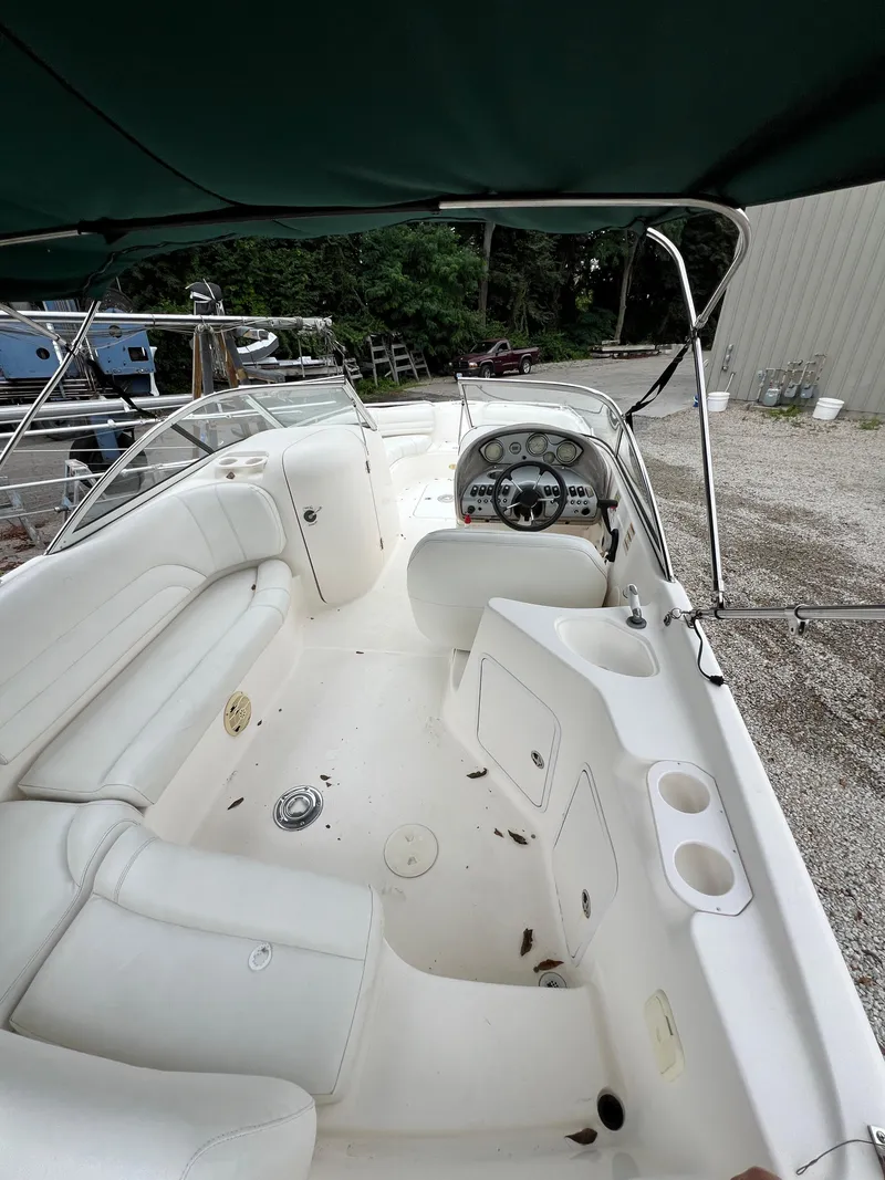 Slide: The Image of 2006 Hurricane SunDeck 237 DC OB boat interior with white seating and steering console. - 9