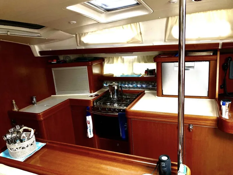 Slide: The Image of 2007 Beneteau Oceanis Clipper 523 yacht interior kitchen with wood finish and modern appliances. - 11