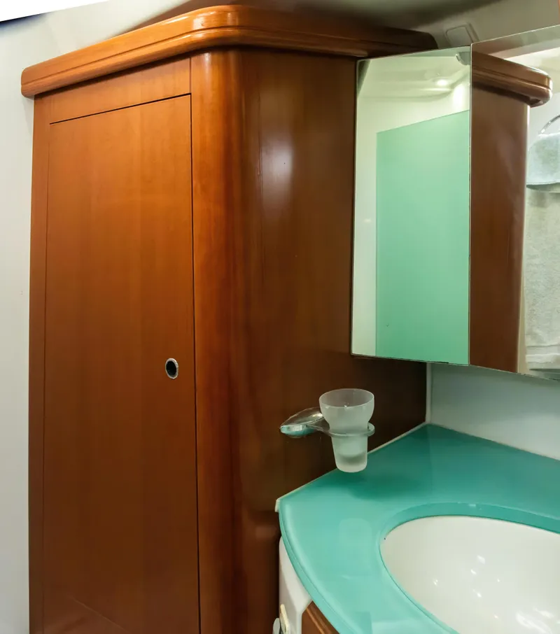 Slide: The Image of 2007 Beneteau Oceanis Clipper 523 bathroom with wooden cabinet and turquoise countertop. - 16