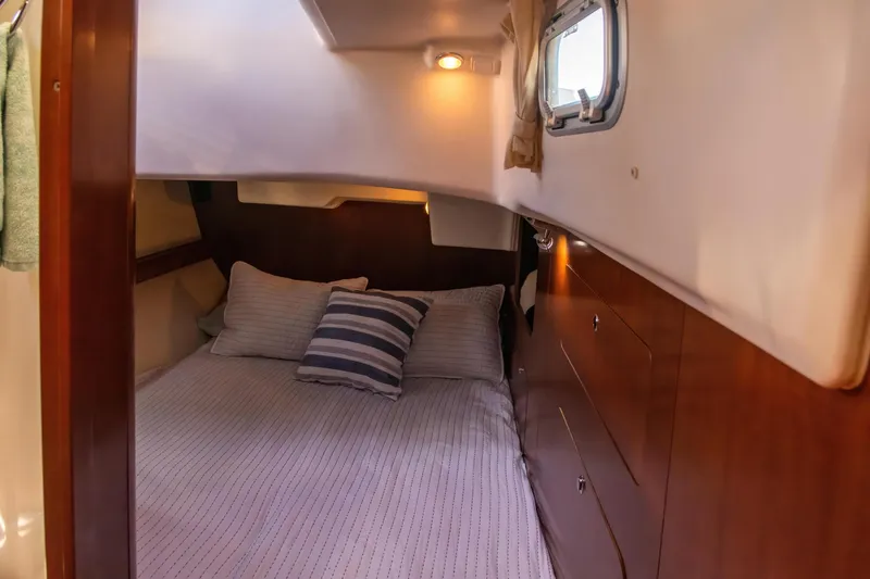 Slide: The Image of Cozy cabin interior of 2007 Beneteau Oceanis Clipper 523 with bed and wooden cabinetry. - 30