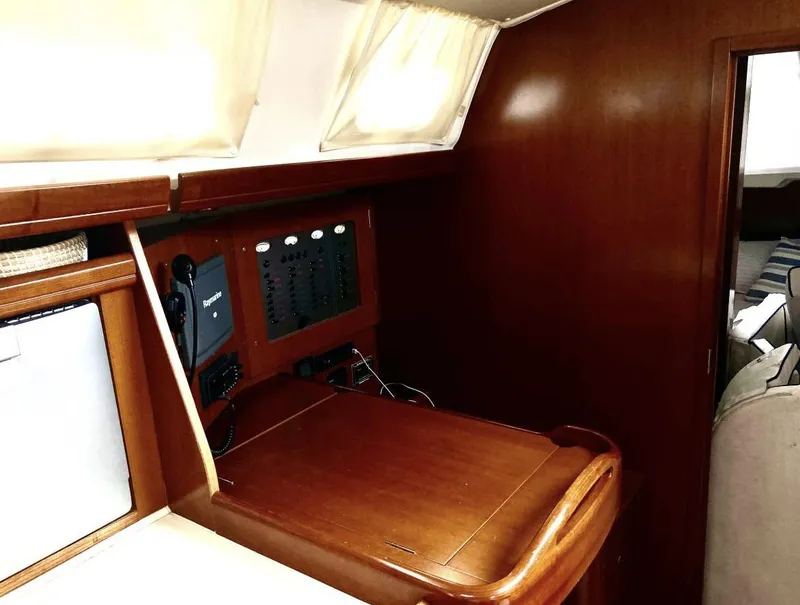 Slide: The Image of 2007 Beneteau Oceanis Clipper 523 interior with navigation station and wooden finish. - 6