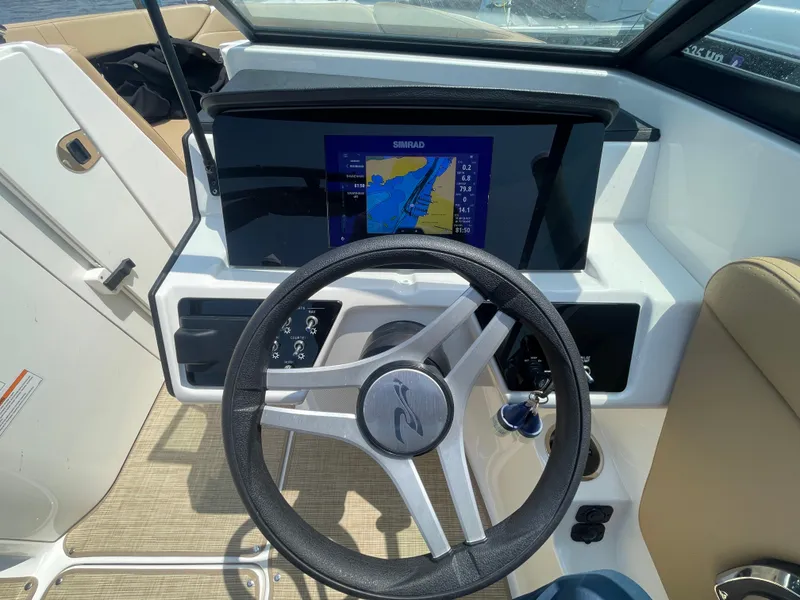 Slide: The Image of 2023 Sea Ray SPX 230 Outboard dashboard with steering wheel and navigation display. - 12