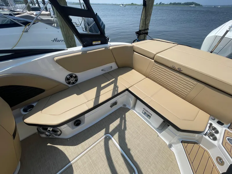 Slide: The Image of 2023 Sea Ray SPX 230 Outboard boat interior with tan seating and lake view. - 22