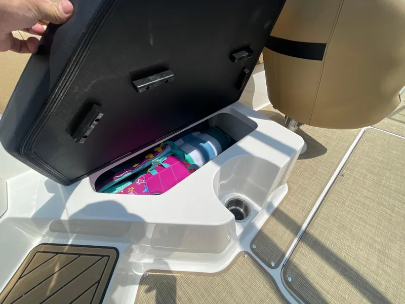 Slide: The Image of 2023 Sea Ray SPX 230 Outboard storage compartment with colorful items inside. - 23