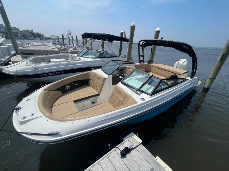Slide: The Image of 2023 Sea Ray SPX 230 Outboard boat docked at marina under clear sky. - 3