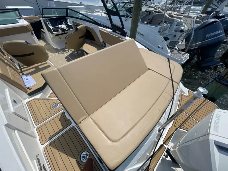 Slide: The Image of 2023 Sea Ray SPX 230 Outboard boat interior with tan seating and modern dashboard. - 30