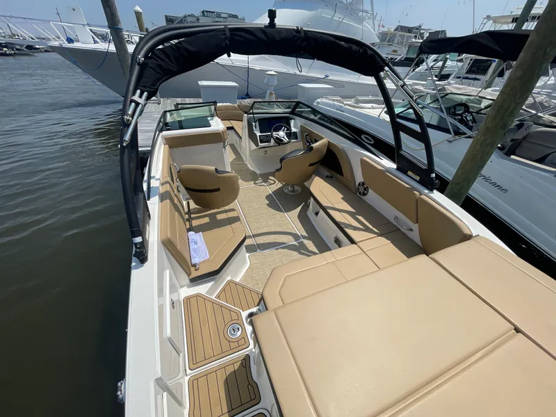 Slide: The Image of 2023 Sea Ray SPX 230 Outboard boat with tan seating, docked at marina. - 32