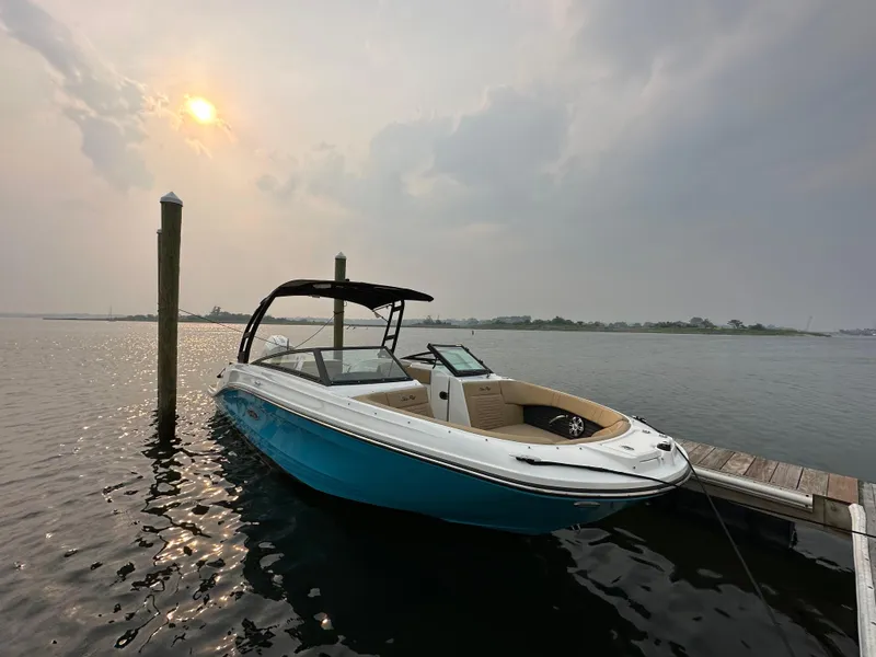 Slide: The Image of 2023 Sea Ray SPX 230 OB boat docked on a serene lake at sunset. - 38