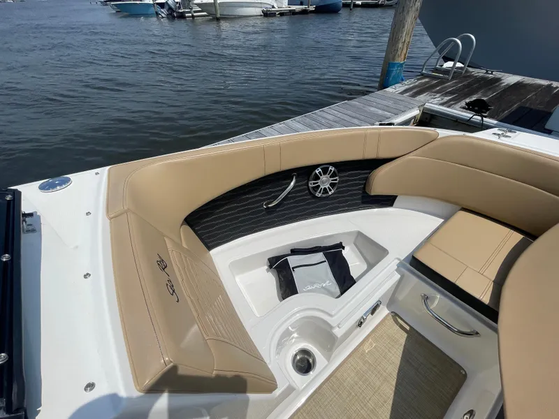 Slide: The Image of 2023 Sea Ray SPX 230 Outboard boat interior with tan seating and storage compartment. - 6