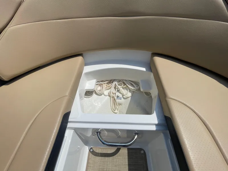 Slide: The Image of 2023 Sea Ray SPX 230 Outboard interior storage with beige seating and rope compartment. - 7