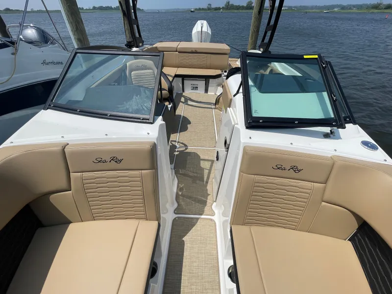 Slide: The Image of 2023 Sea Ray SPX 230 Outboard boat interior with tan seating and open water view. - 9