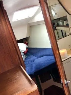 Slide: The Image of Interior cabin of 1984 Hunter 31 sailboat with blue bedding and wooden accents. - 13