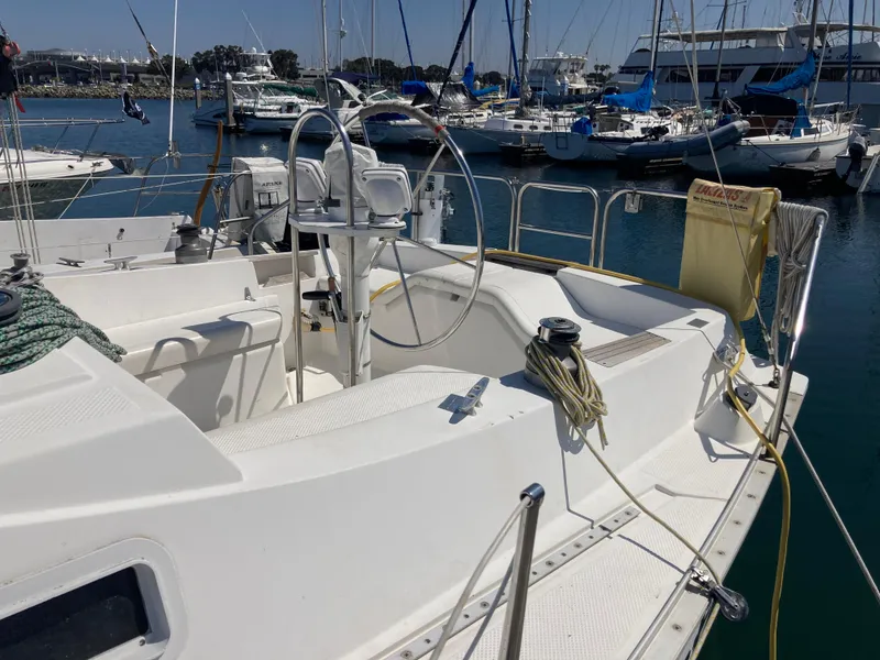Slide: The Image of 1984 Hunter 31 sailboat cockpit in marina, featuring steering wheel and mooring lines. - 35