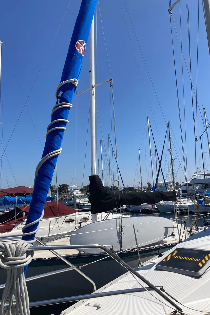 Slide: The Image of 1984 Hunter 31 sailboat docked in a marina under clear blue skies. - 38