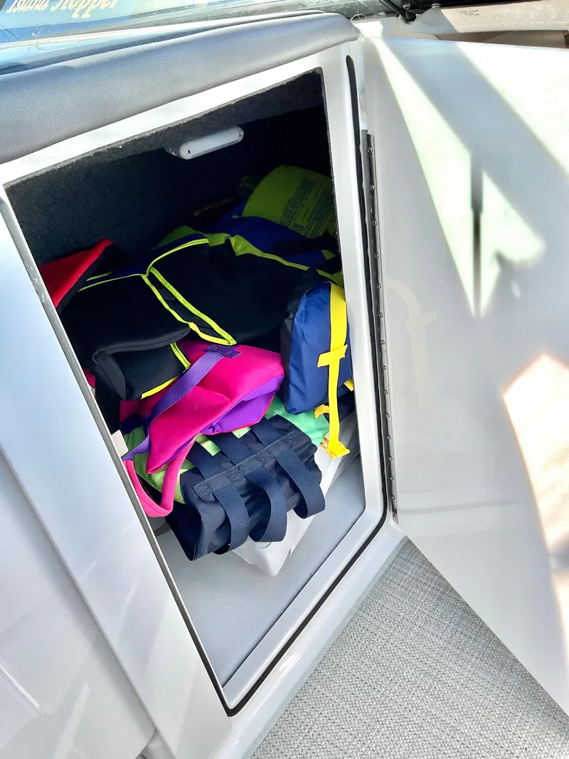 Slide: The Image of Storage compartment with colorful life jackets on a 2022 Formula 350 Crossover Bowrider I/O. - 33