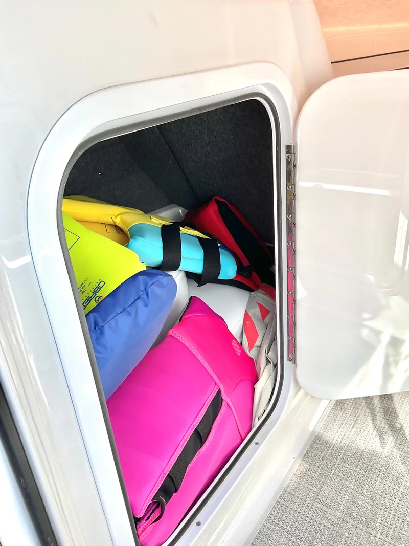 Slide: The Image of Storage compartment with colorful life jackets in a 2022 Formula 350 Crossover Bowrider I/O. - 35