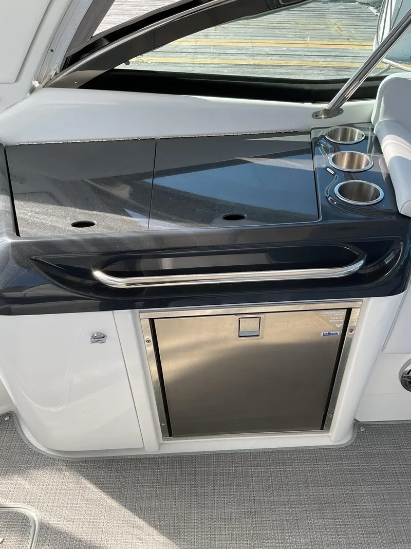 Slide: The Image of 2022 Formula 350 Crossover Bowrider I/O interior with sleek kitchenette and stainless steel fridge. - 44