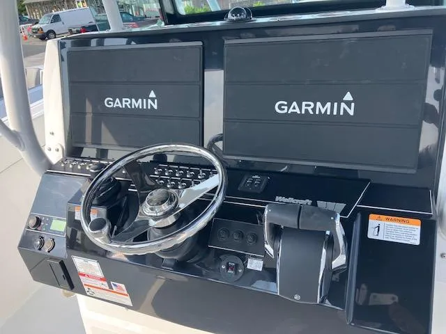 Slide: The Image of 2025 Wellcraft 352 Fisherman dashboard with Garmin navigation displays and steering wheel. - 12