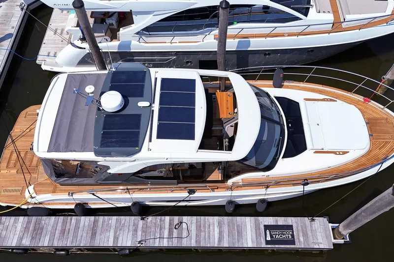 Slide: The Image of 2026 Marex 440 yacht docked, featuring sleek design and solar panels on the roof. - 2