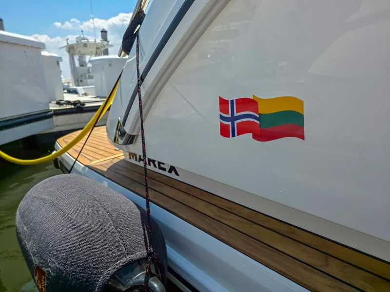 Slide: The Image of 2026 Marex 440 yacht with Norwegian and Lithuanian flags docked at marina. - 28