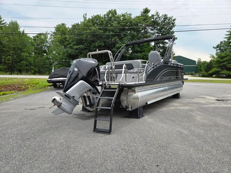 Slide: The Image of 2025 Harris Solstice 230 pontoon boat with outboard motor in a parking lot. - 4
