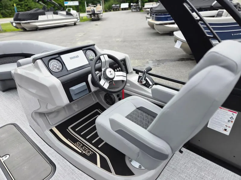 Slide: The Image of 2025 Harris Solstice 230 boat interior with modern steering and dashboard controls. - 7
