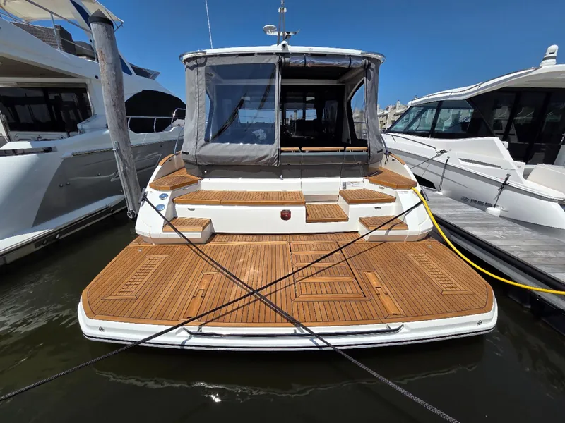 Slide: The Image of 2026 Marex 440 yacht with teak deck, docked at marina under clear blue sky. - 11