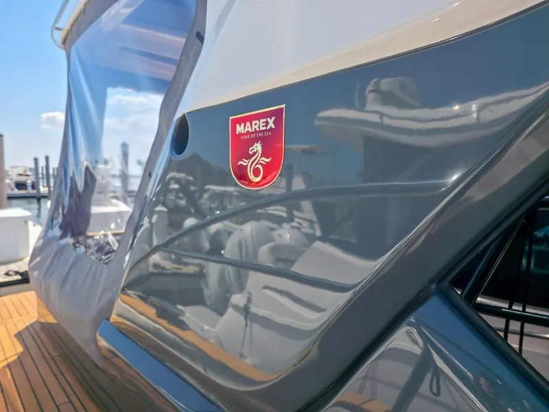 Slide: The Image of 2026 Marex 440 yacht with sleek design and logo, docked under clear blue sky. - 31